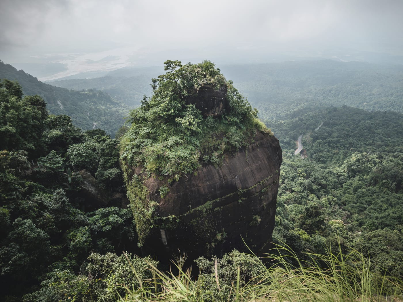 Khoh Ramhah — the giant's basket rock — crowned in green above the misty Bangladesh plains