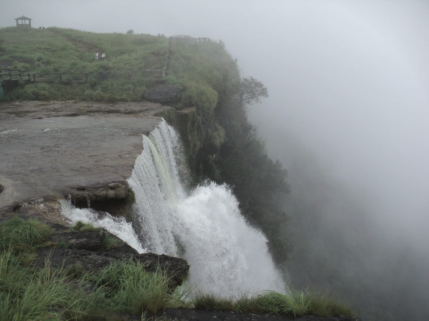 Standing on top of Seven Sisters at Eco Park — water leaping off the edge into monsoon mist